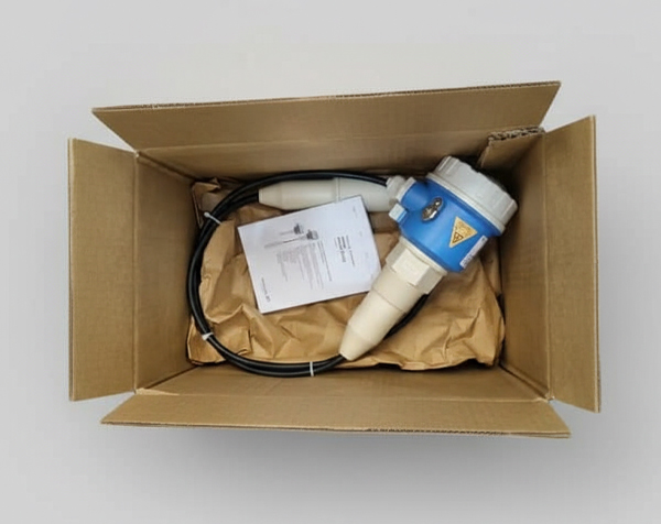 یک سنسور صنعتی در جعبه بستهبندی آن به همراه دفترچه راهنما و کابلها.