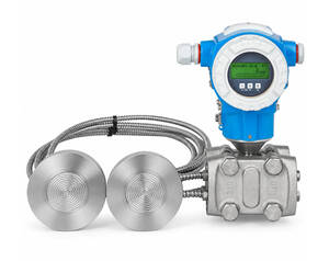 Industrial flow meter with blue digital transmitter and two stainless steel sensor heads connected by braided cables.