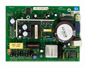 Green power-supply circuit board featuring a large round transformer, electrolytic capacitors, heat sink, transformers, connectors, and caution markings (Ex logo).